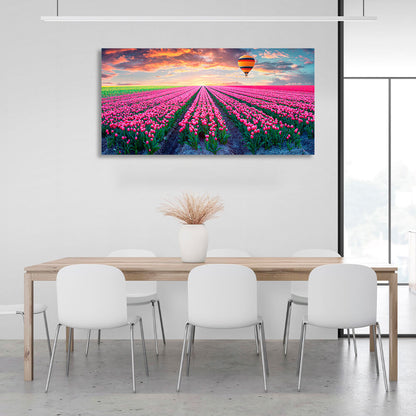 A field of pink tulips against the backdrop of dawn and a hot air balloon Canvas Wall Art Print