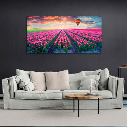 A field of pink tulips against the backdrop of dawn and a hot air balloon Canvas Wall Art Print