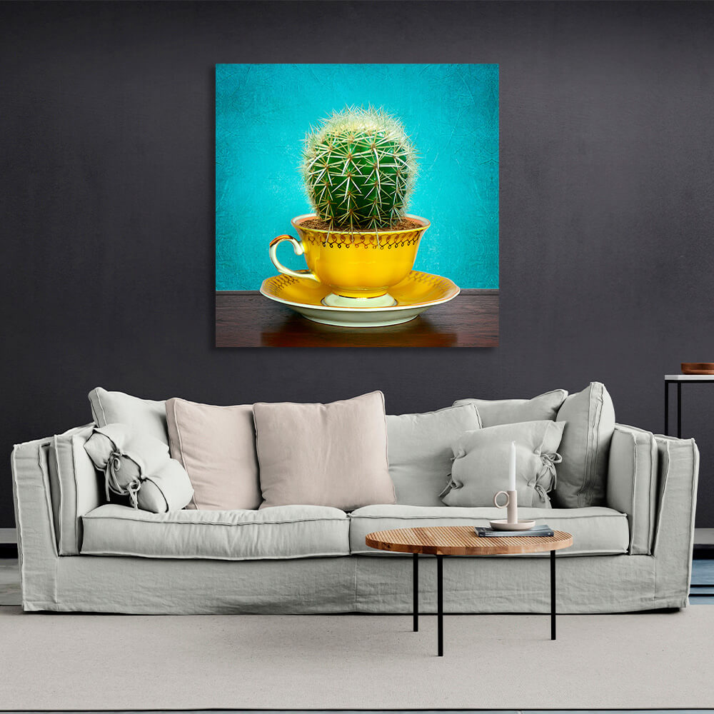 Cactus in cup on saucer on turquoise background Canvas Wall Art Print