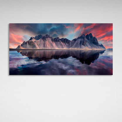 A rock in the sea against a red and blue sky Canvas Wall Art Print