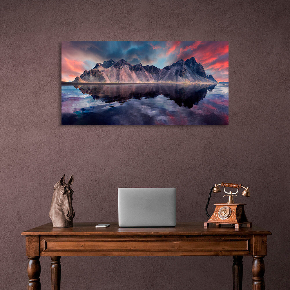 A rock in the sea against a red and blue sky Canvas Wall Art Print