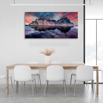 A rock in the sea against a red and blue sky Canvas Wall Art Print